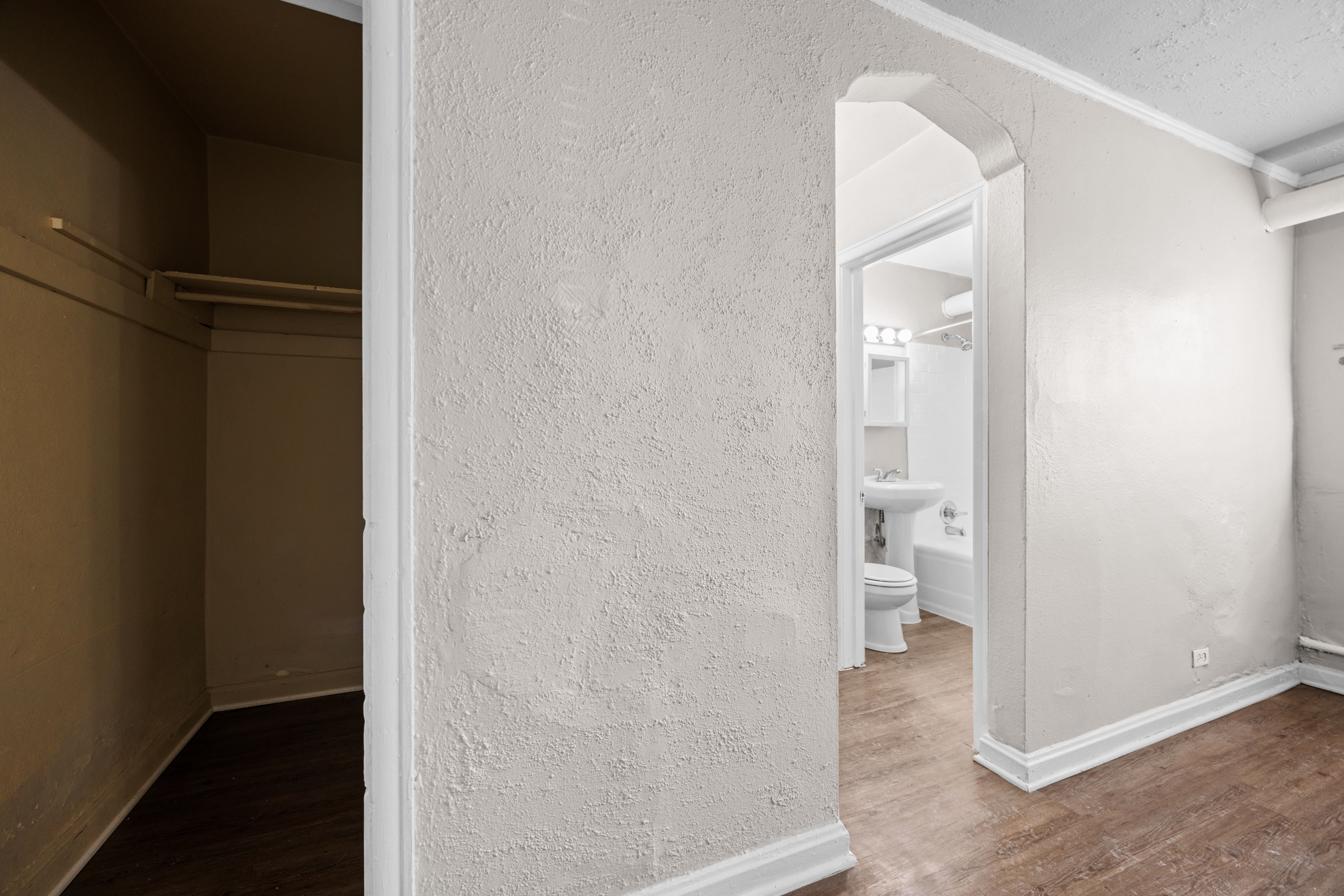 A bathroom with a toilet and sink is visible through an open doorway.
